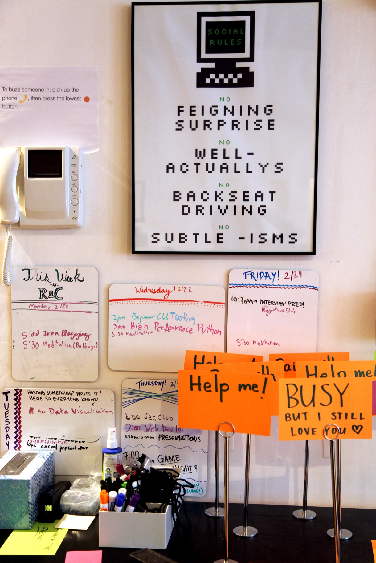 Poster with the following contents: “Social Rules: No Feigning Surprise, No Well-Actually’s, No Backseat Driving, No Subtle -isms”. Below the poster are signs that read “Help me!” and “BUSY, but I still love you <3”